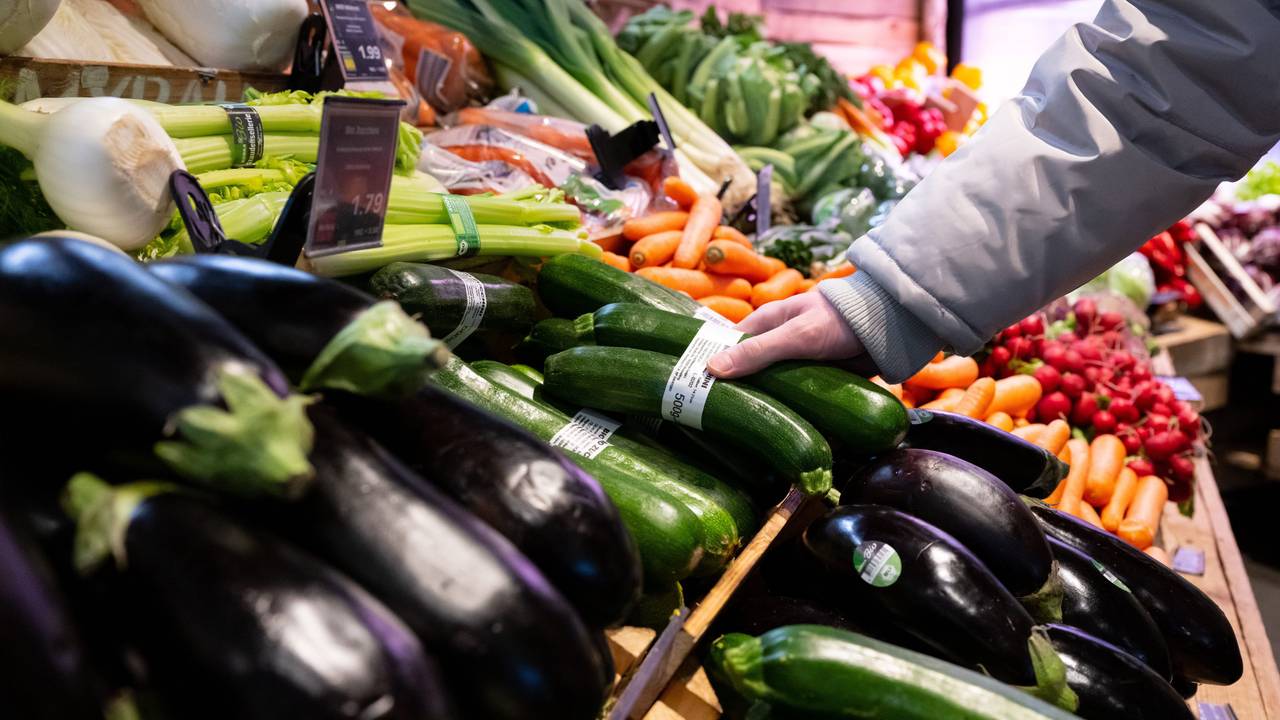 Hier zu sehen, eine Person greift nach einem Doppelpack Zucchini in der Gemüseabteilung eines Supermarktes.