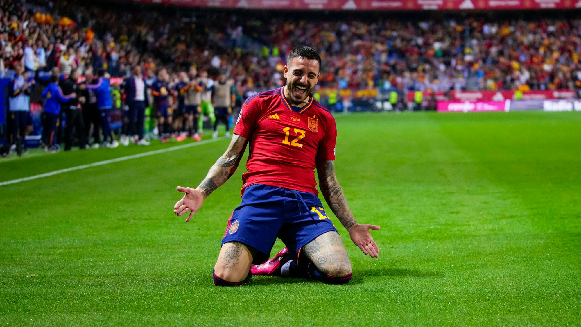 Joselu rutscht beim Jubel nach einem Tor für Spanien auf Knien über den Rasen.