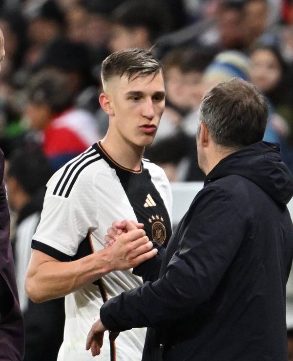 Deutschlands Nico Schlotterbeck (M) nimmt nach seiner Auswechslung die Glückwünsche von Bundestrainer Hansi Flick entgegen.