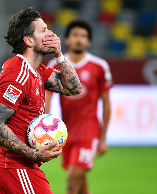 Daniel Ginczek hält den Ball in der Hand und legt die Hand vor den Mund.