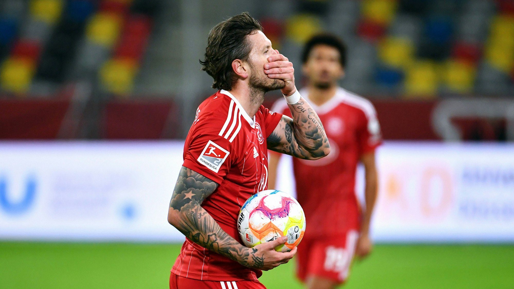 Daniel Ginczek hält den Ball in der Hand und legt die Hand vor den Mund.