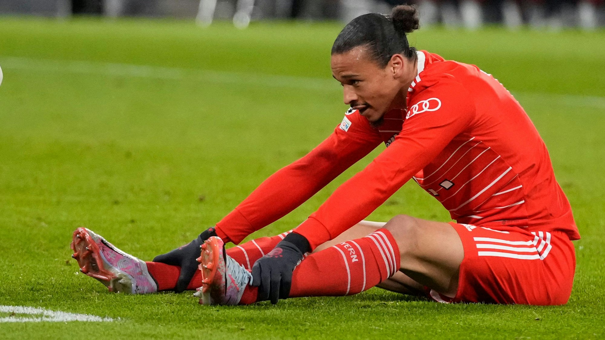 Leroy Sané sitzt beim Spiel der Bayern gegen PSG auf dem Boden.