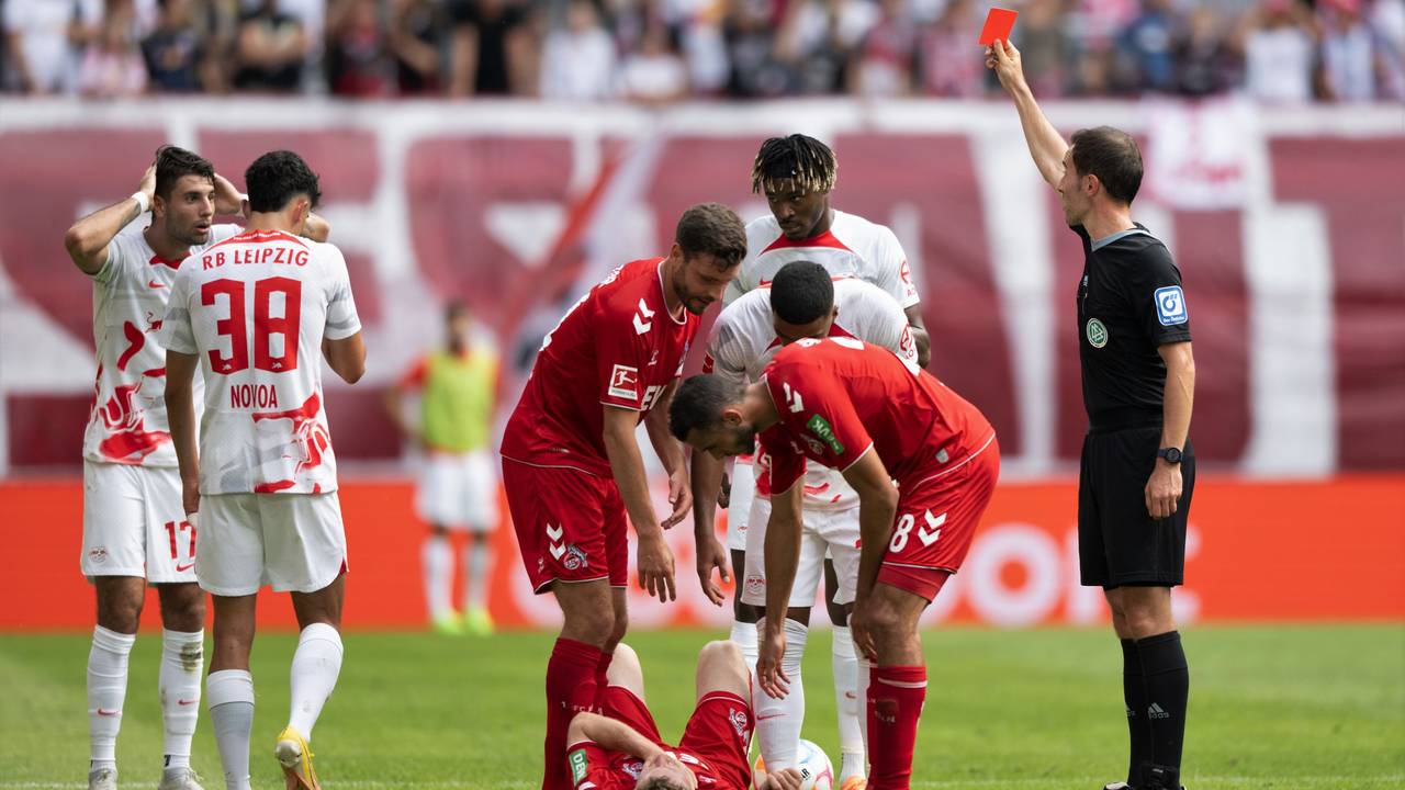 Leipzigs Dominik Szoboszlai (l) bekommt von Schiedsrichter Benjamin Brand die Rote Karte gezeigt.