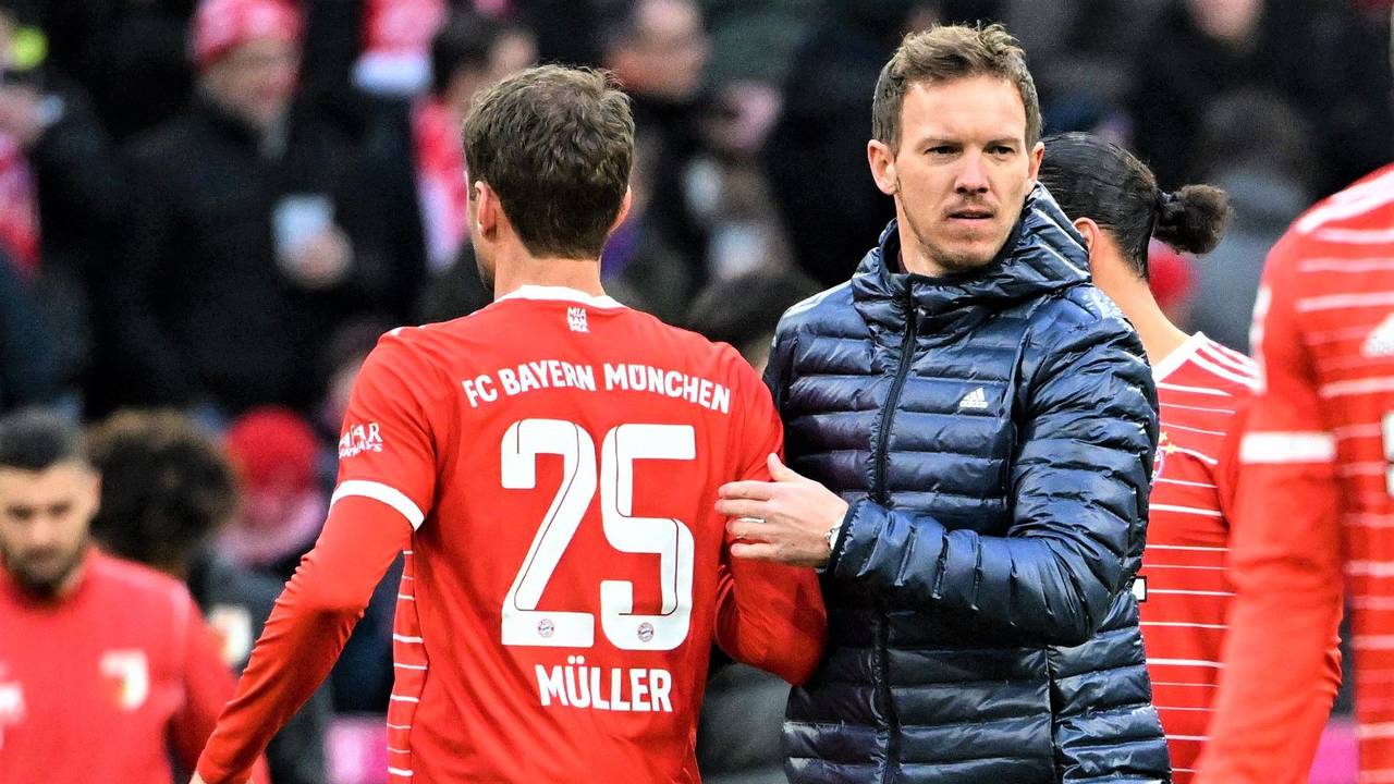 Thomas Müller und Trainer Julian Nagelsmann vom FC Bayern München stehen nach dem Spiel auf dem Platz und klatschen ab.