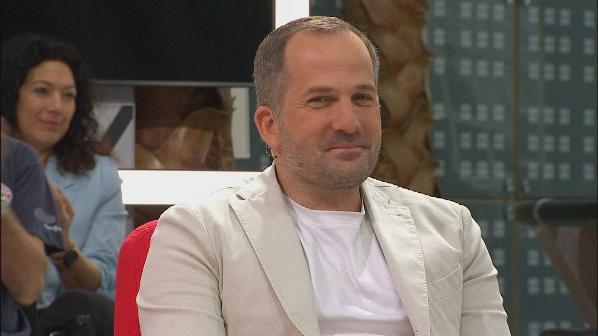 Manuel Baum blickt in der Doppelpass-Runde auf Sport1 lächelnd in die Kamera.
