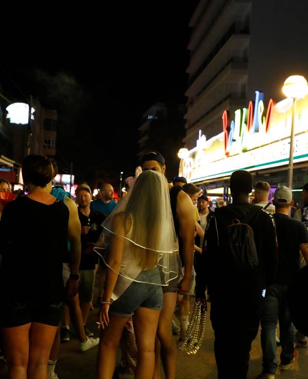 In der Bierstraße am Ballermann gehen Menschen an den Bars Bierkonig und Bamboleo vorbei.