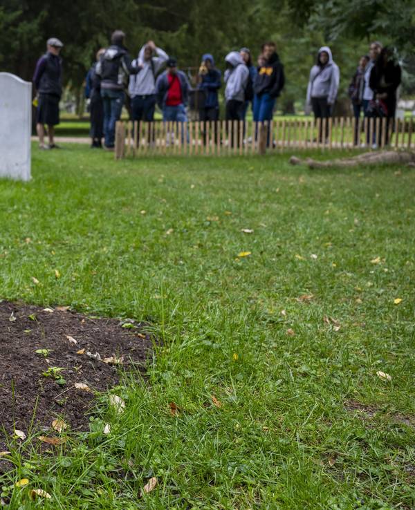 Das Symbolfoto aus dem Jahr 2022 zeigt ein frisches Grab auf einer grünen Wiese. Aus der Erde ragen zwei steinerne Hände, die zum Gebet aneinandergelehnt sind.