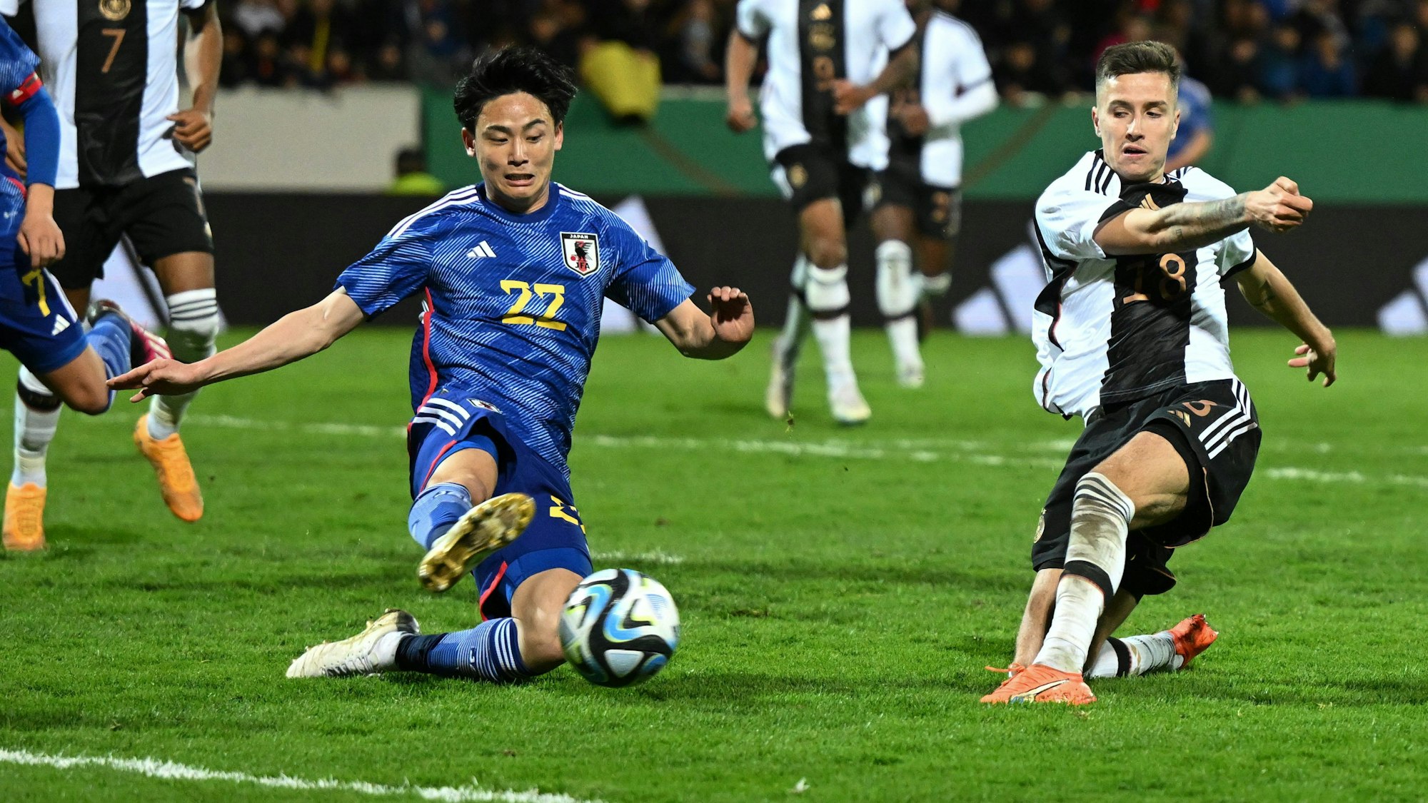 Denis Huseinbasic (r) und Japans Takashi Uchino kämpfen um den Ball.