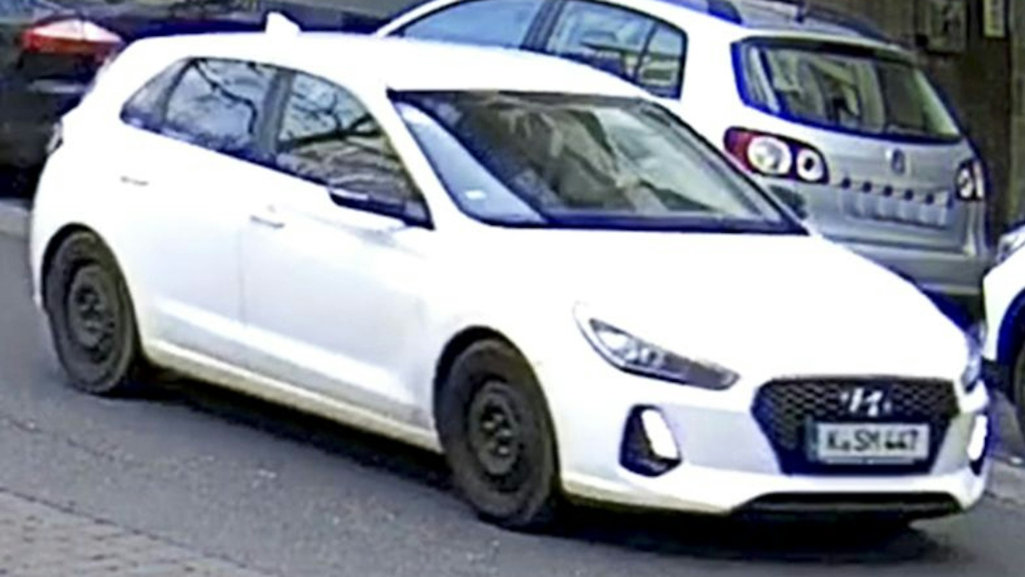 Ein weißer Hyundai steht in zweiter Reihe auf der Straße.