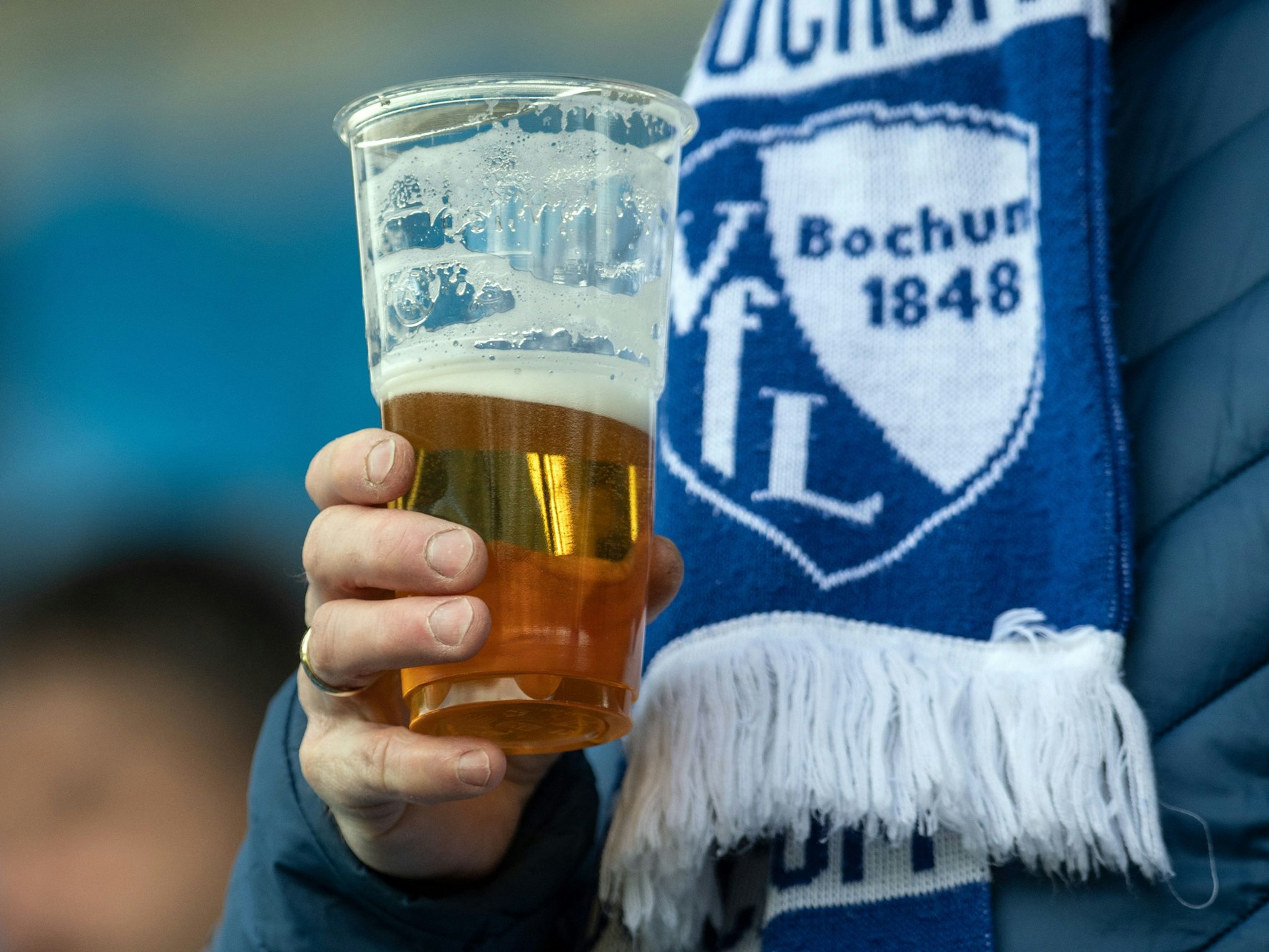 Ein Fan hält seinen Becher mit Bier in der Hand.