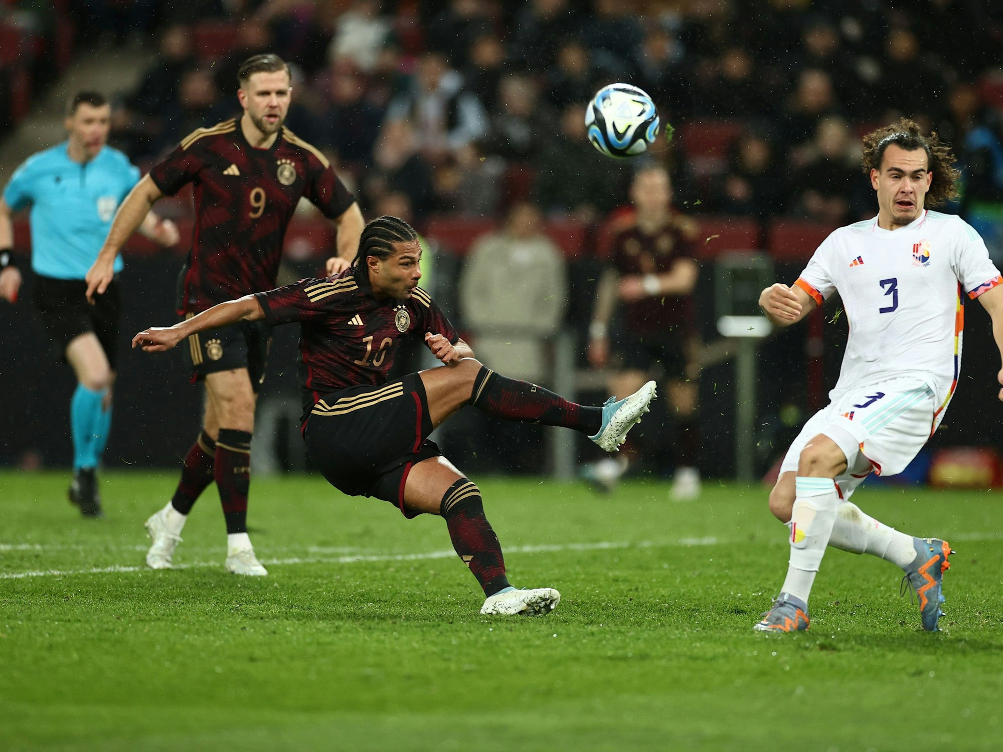 Deutschland - Belgien, Rhein-Energie-Stadion: Deutschlands Serge Gnabry (M) kommt gegen Belgiens Arthur Theate zum Torschuss.