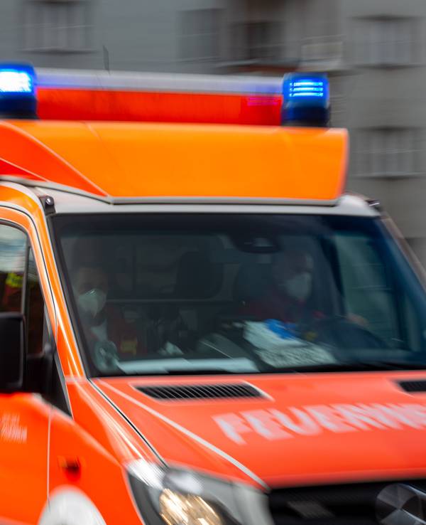 Ein Rettungswagen der Feuerwehr fährt auf einer Straße.