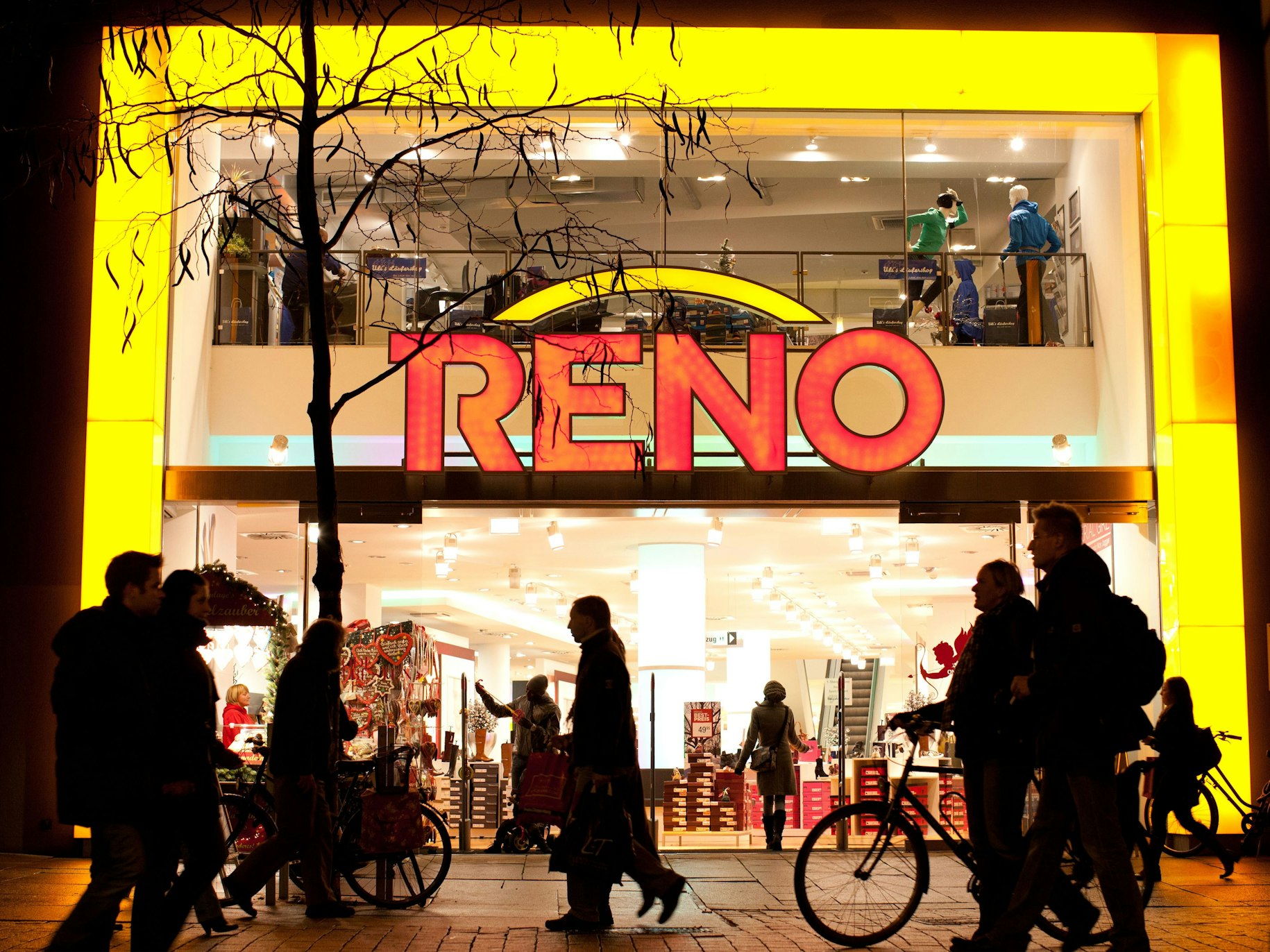 Passanten laufen am 26.11.2012 in Osnabrück (Niedersachsen) am Flagship-Store des Schuhgeschäftes Reno entlang.