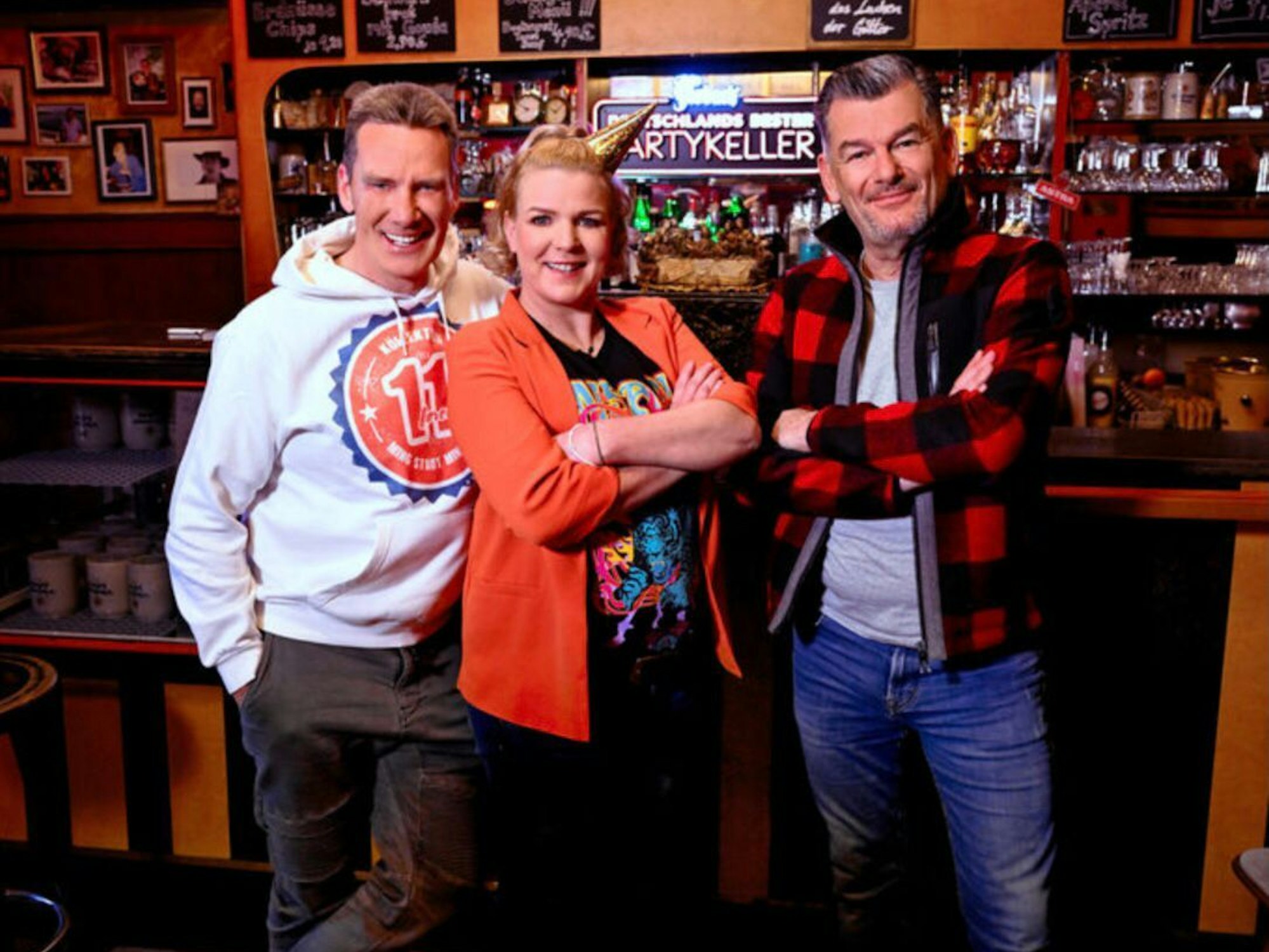 Jürgen Milski, Mirja Boes und Mark Kühler stehen in einem Partykeller.