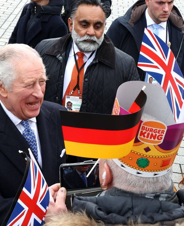 König Charles III. steht in Berlin inmitten wartender Fans.