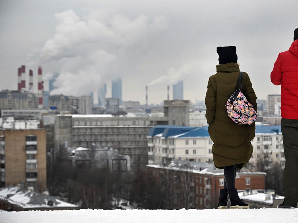 Auf unserem Foto stehen zwei Menschen Mitte Februar auf einem Hügel mit Blick auf Moskau.