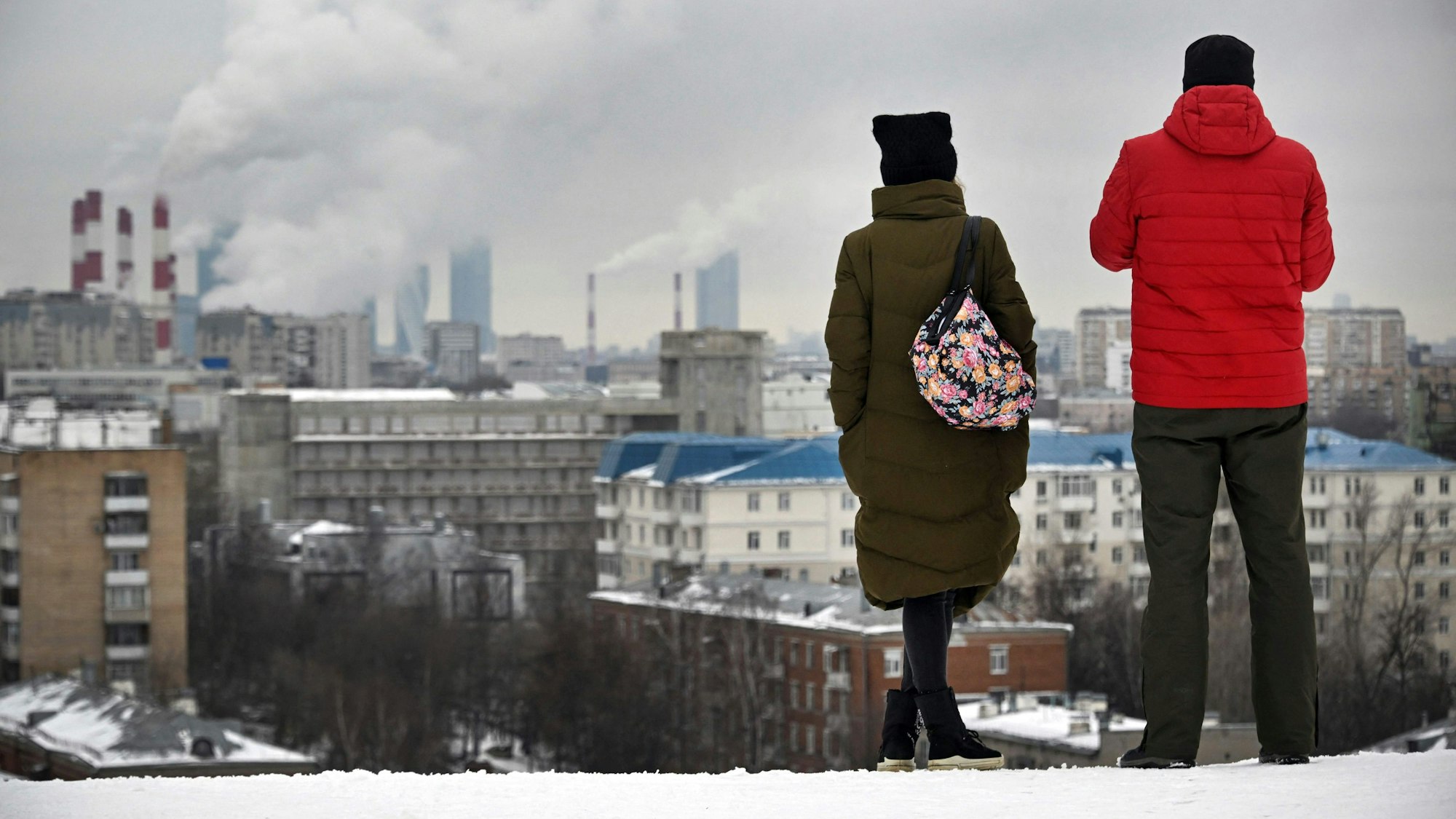 Auf unserem Foto stehen zwei Menschen Mitte Februar auf einem Hügel mit Blick auf Moskau.