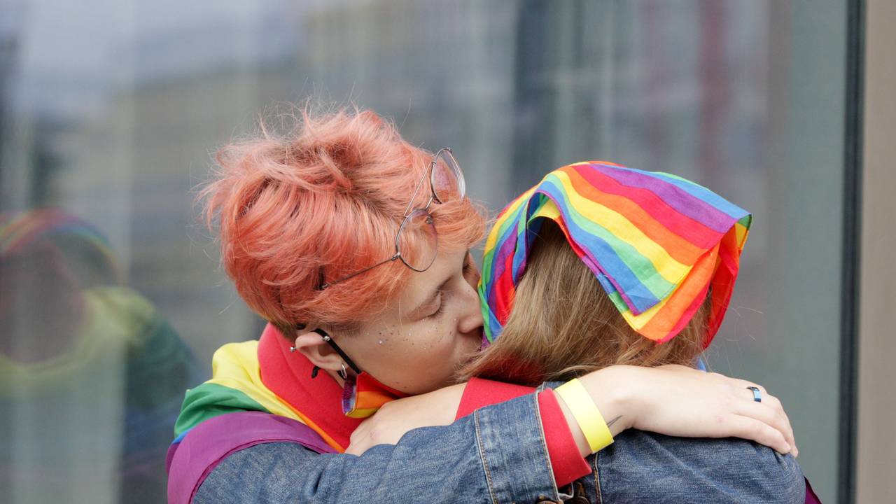 Das Foto aus dem Jahr 2021 zeigt zwei Frauen, die sich küssen. Beide tragen Regenbogenflaggen, das offizielle Symbol der LGBTQI+-Community.