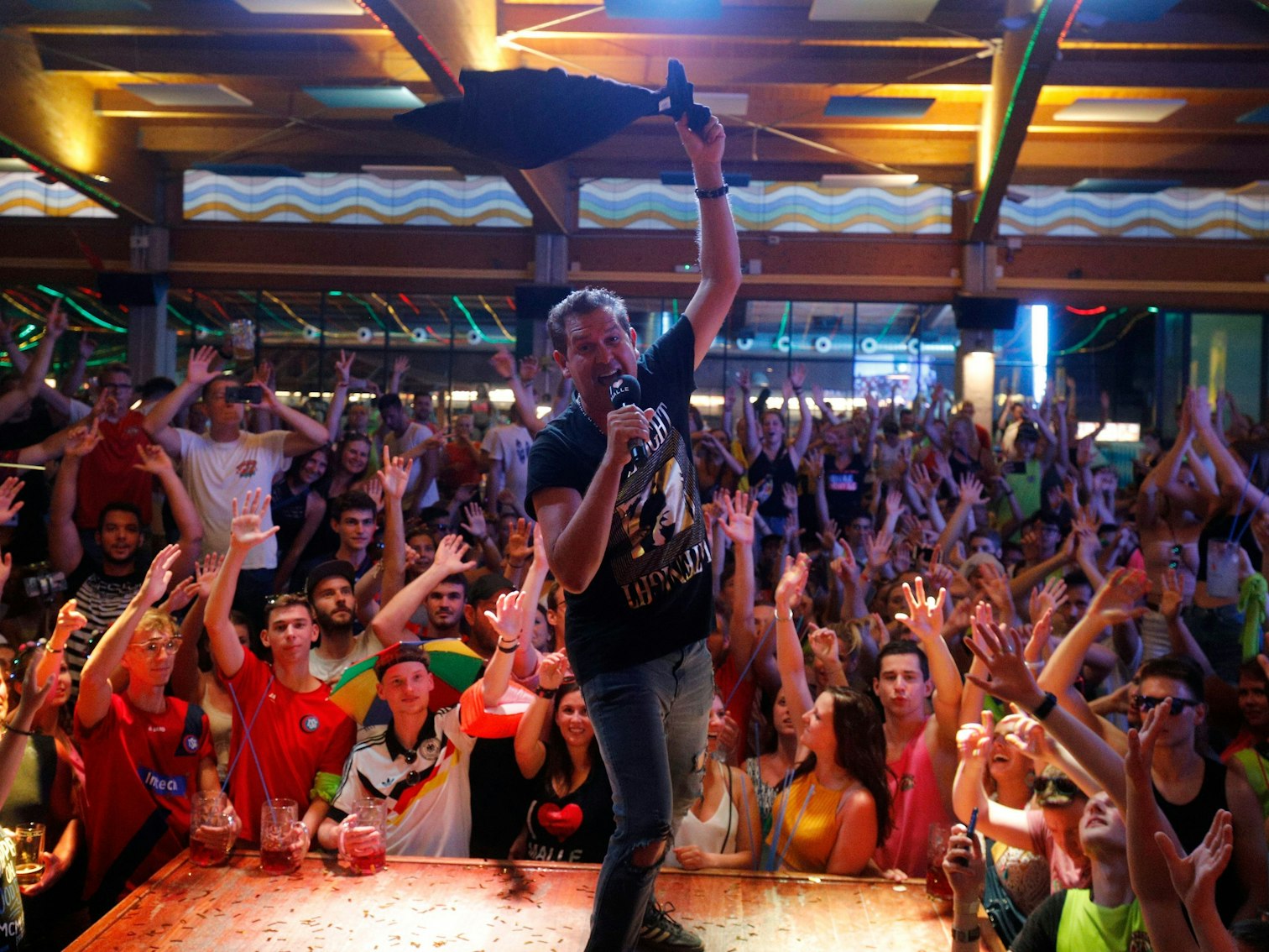 Sänger Peter Wackel singt im Bierkönig, um ihn herum stehen Feiernde.