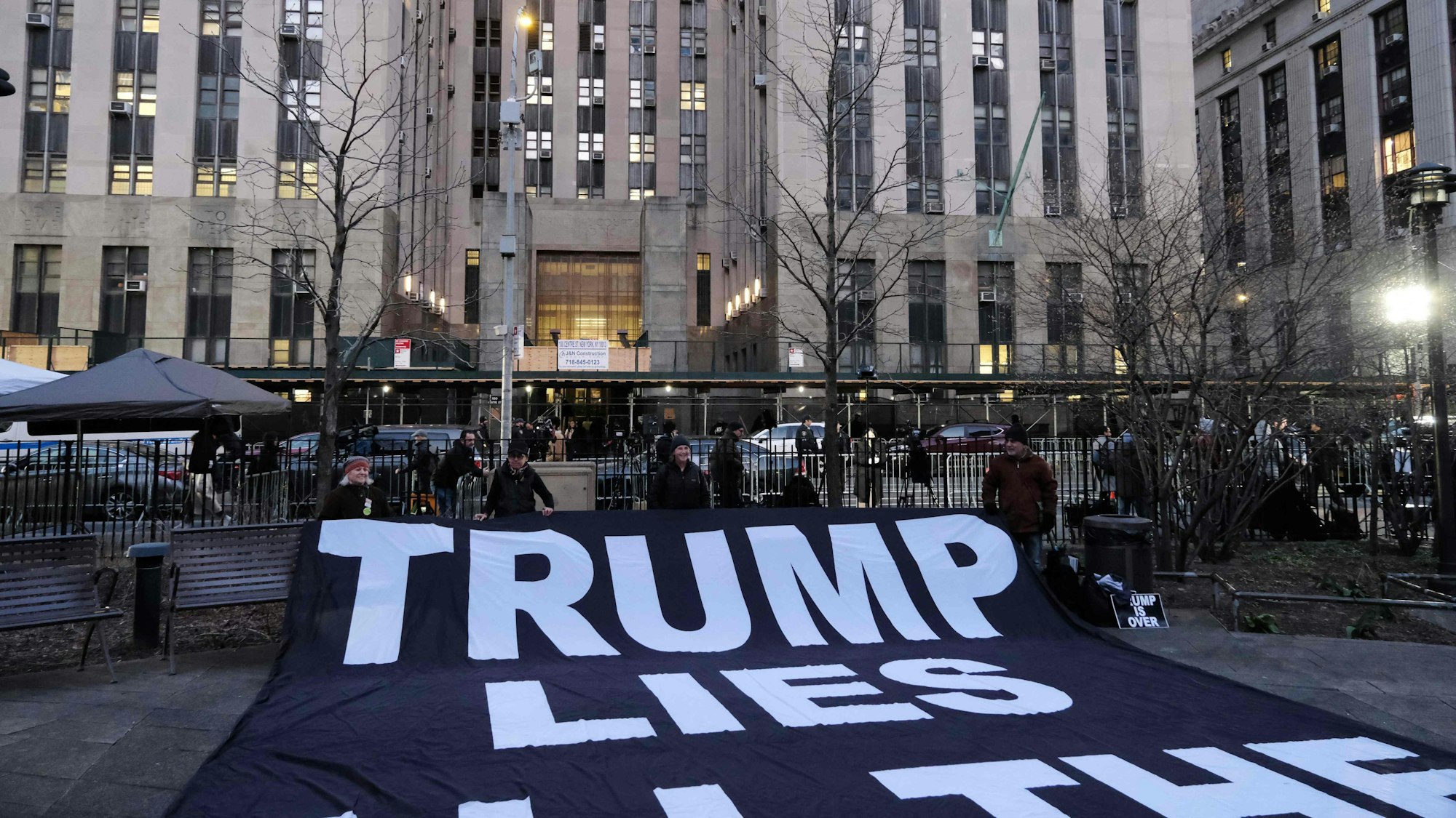 Polizei, Medien und eine Gruppe von Demonstrantinnen und Demonstranten versammeln sich vor einem Gerichtsgebäude in Manhattan.