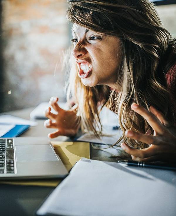 Frau vor dem Laptop die sich aufregt