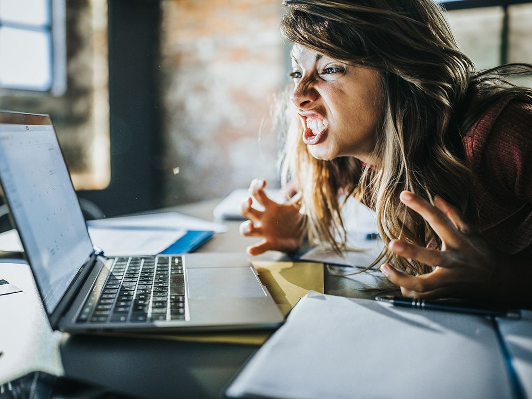 Frau vor dem Laptop die sich aufregt