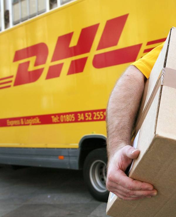 Symbolbild: Ein Mitarbeiter des Paketdienstleisters DHL der Deutschen Post trägt am 12.11.2008 in Köln ein Paket zum Kunden.