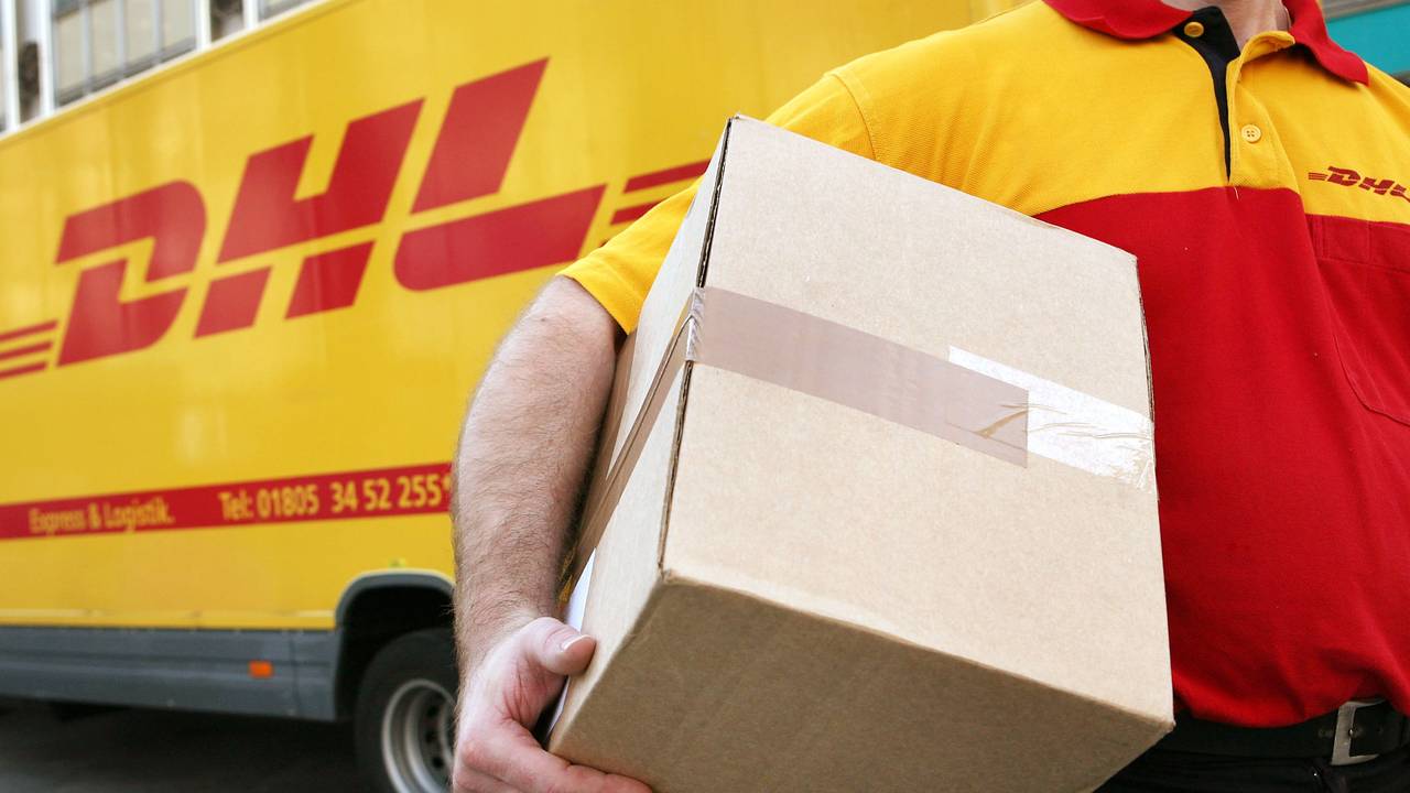 Symbolbild: Ein Mitarbeiter des Paketdienstleisters DHL der Deutschen Post trägt am 12.11.2008 in Köln ein Paket zum Kunden.