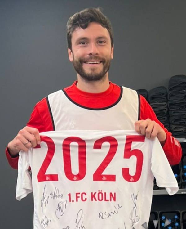 Jonas Hector hält ein Trikot in die Kamera.