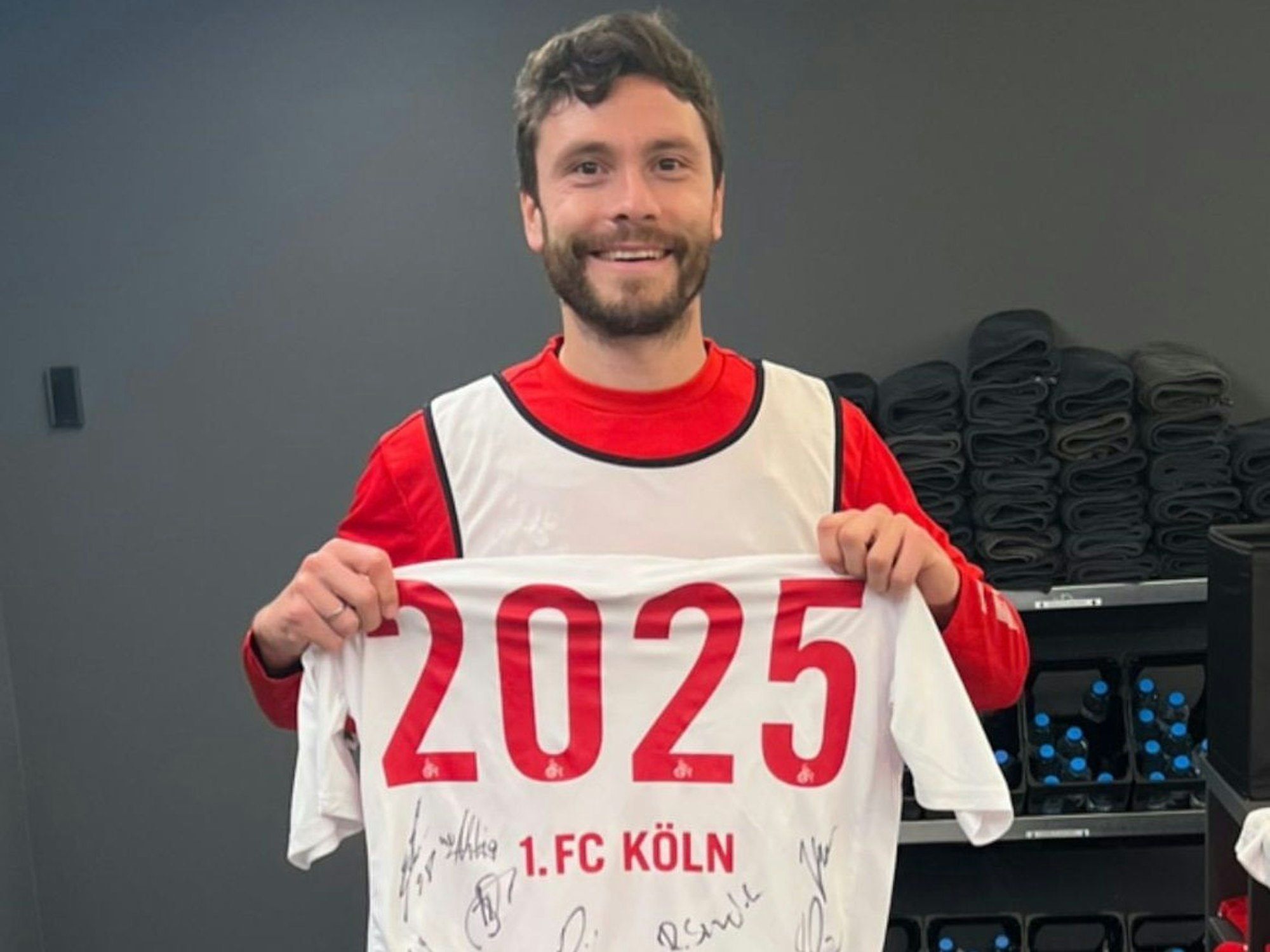 Jonas Hector hält ein Trikot in die Kamera.