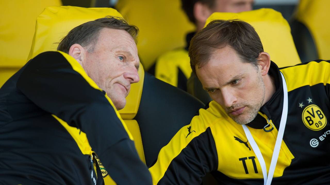 Dortmunds damaliger Trainer Thomas Tuchel (r) sitzt einem Spiel auf der Trainerbank und unterhält sich mit Dortmunds Geschäftsführer Hans-Joachim Watzke (l).