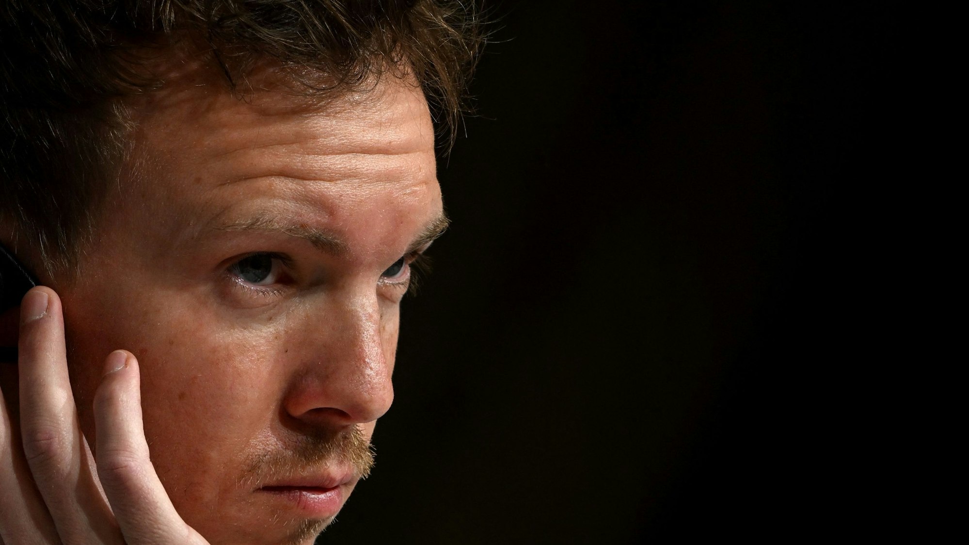 Julian Nagelsmann hört bei einer Pressekonferenz ganz genau zu.