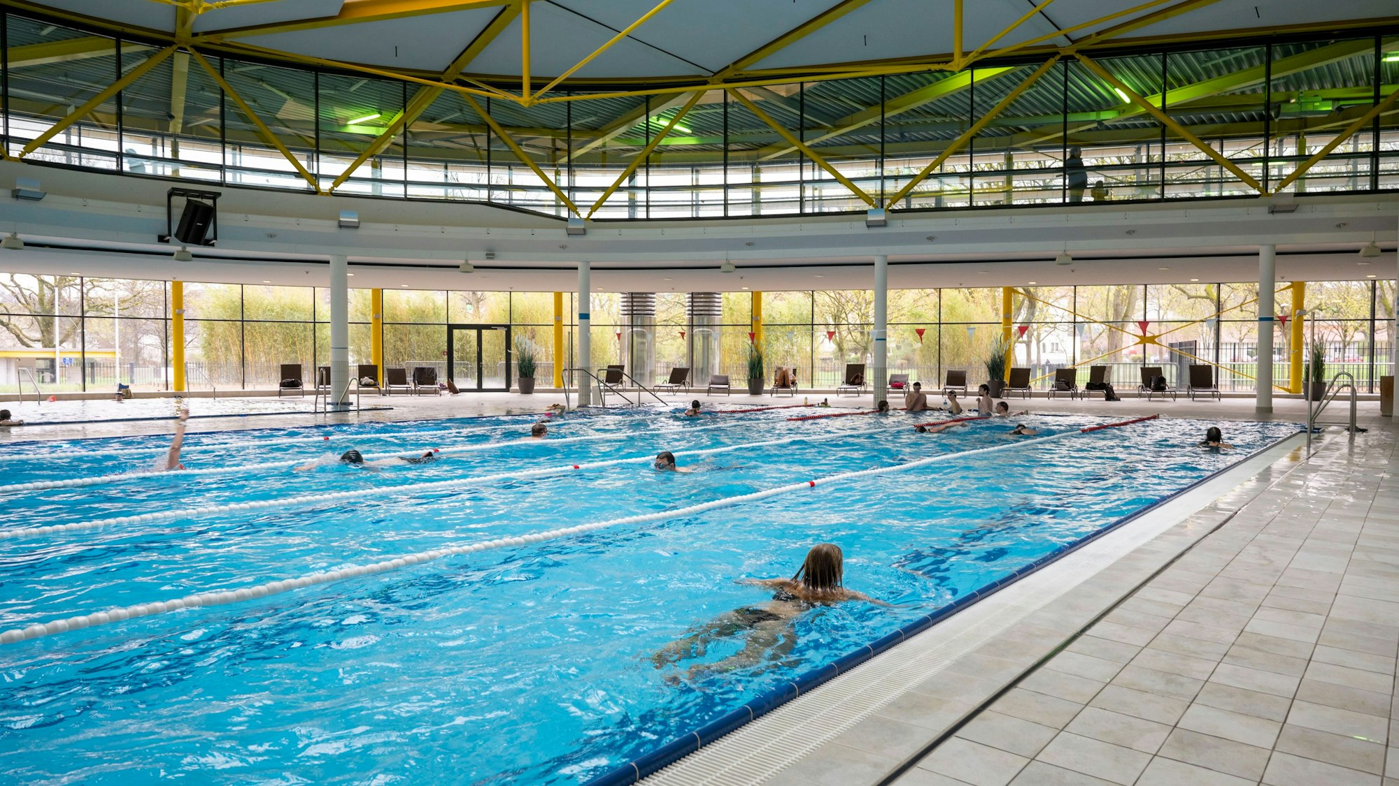 Menschen schwimmen im Hallenbad des Lentparks in Köln.