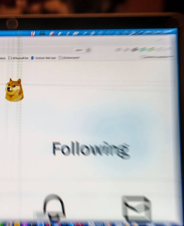 Auf einem Laptop-Display ist die Startseite von Twitter zu sehen, die anstelle des Twitter-Logos das Symbol der Digitalwährung Dogecoin zeigt.