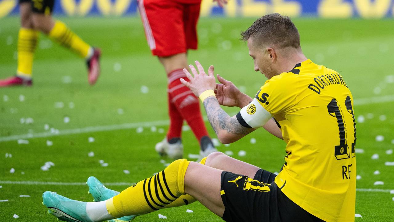 Marco Reus von Dortmund sitzt auf dem Rasen.
