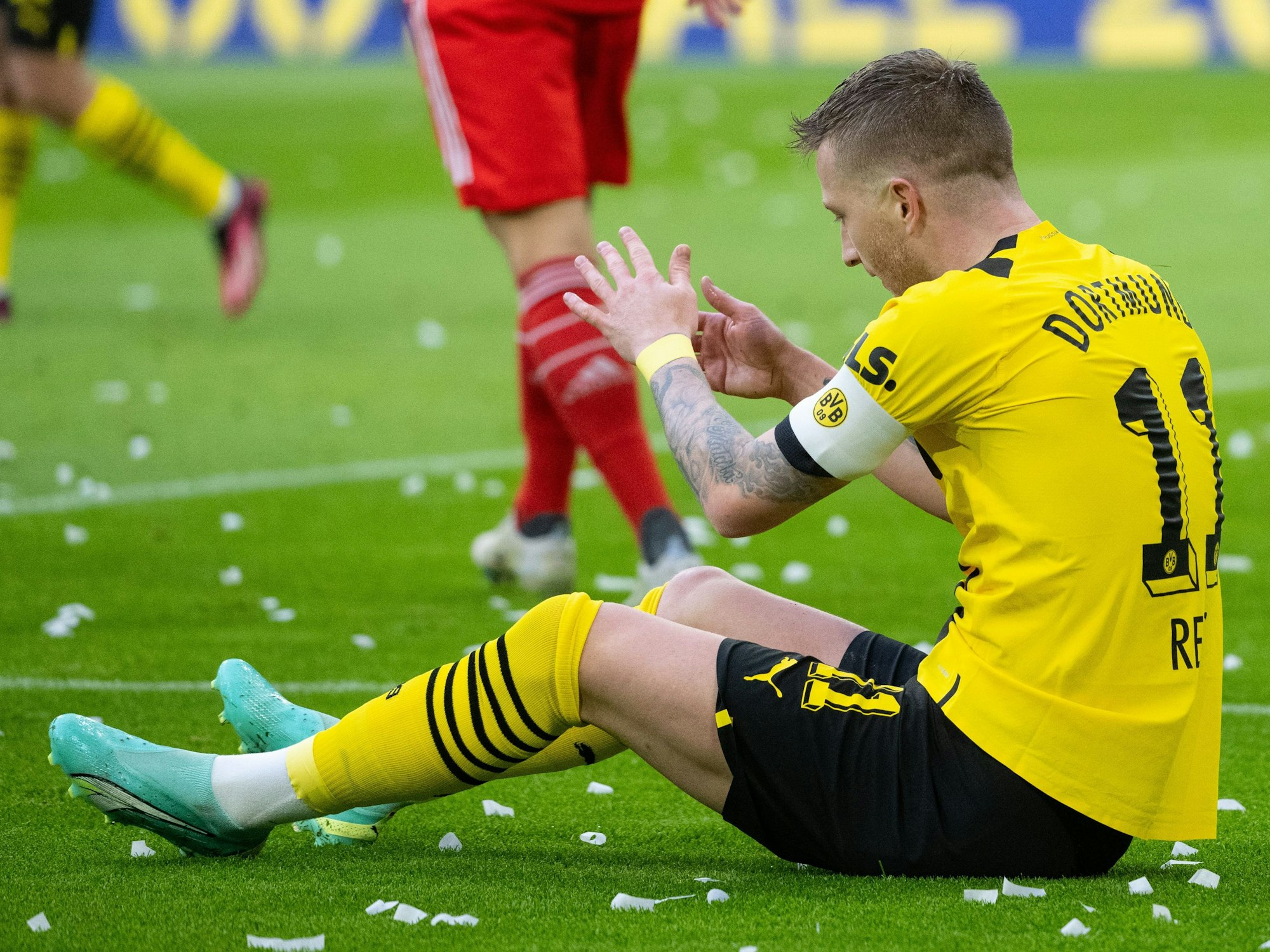 Marco Reus von Dortmund sitzt auf dem Rasen.