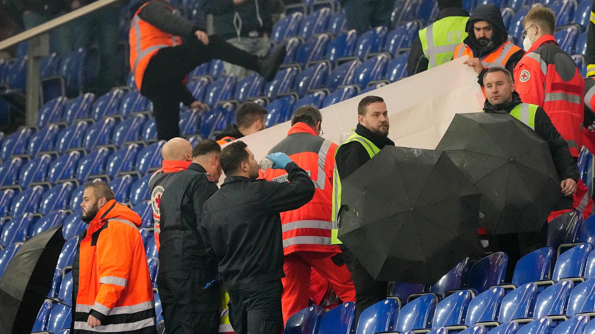 Sanitäter kümmern sich um einen Zuschauer auf der Tribüne im Schalke-Stadion.