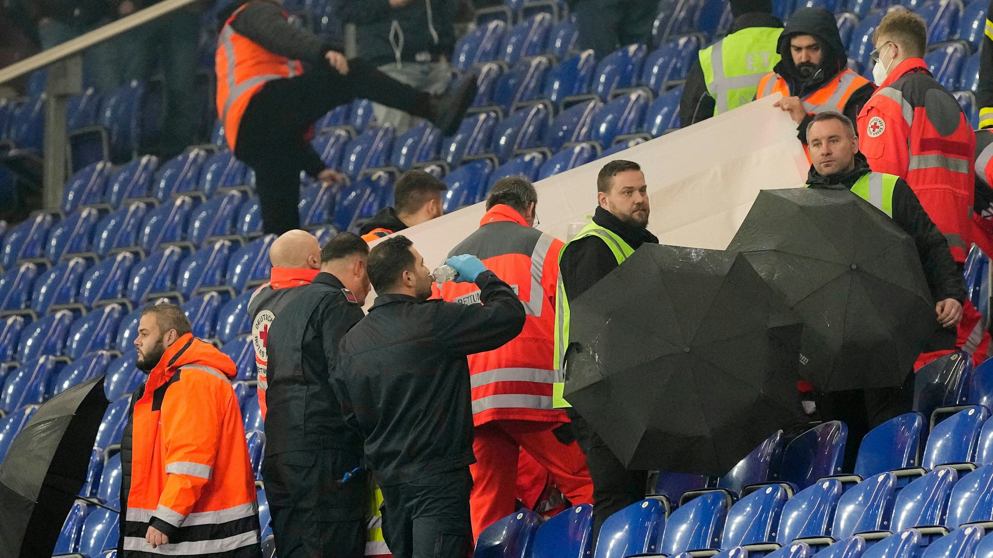 Sanitäter kümmern sich um einen Zuschauer auf der Tribüne im Schalke-Stadion.
