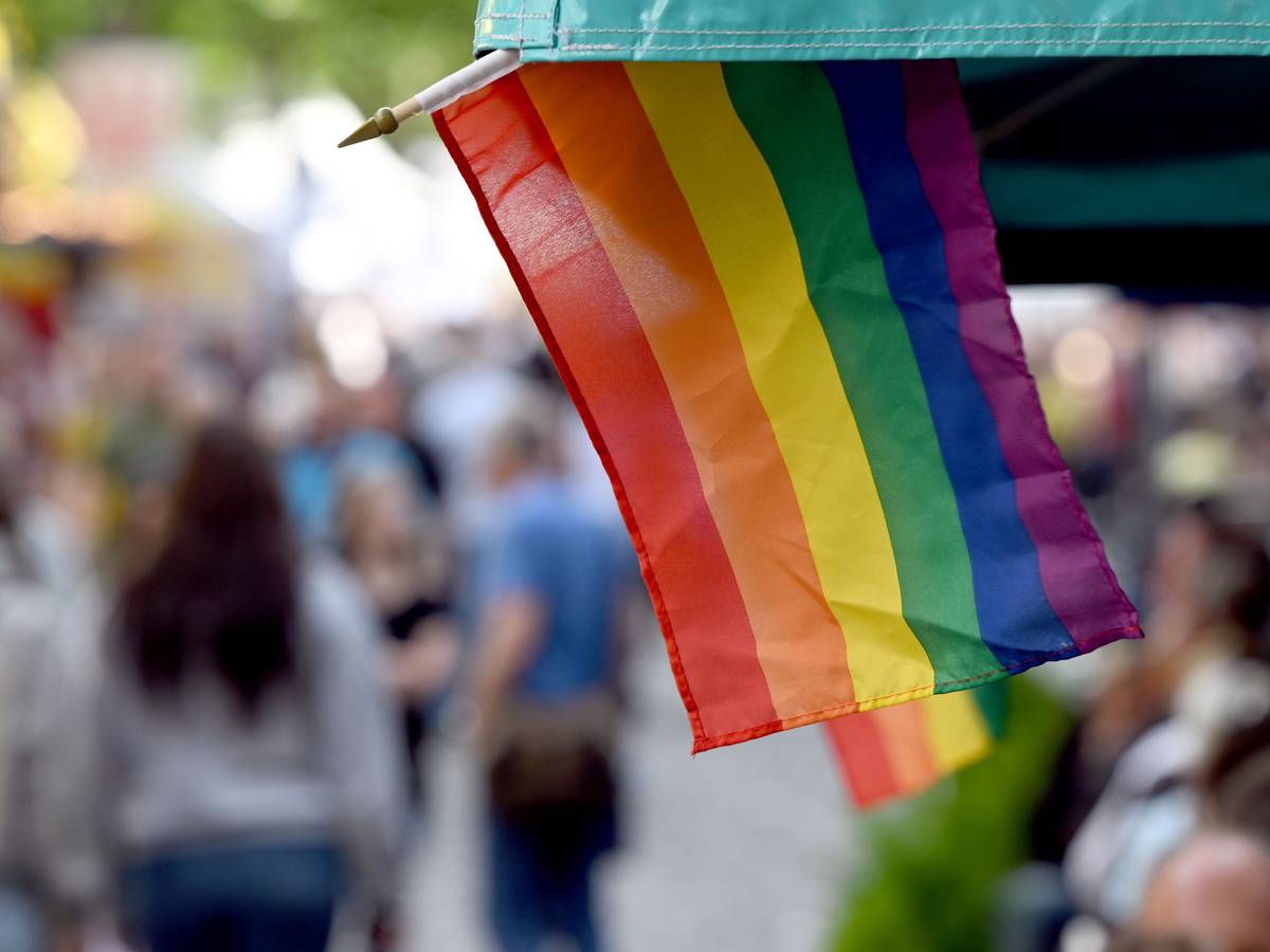 Regenbogenflaggen sind an einem Marktstand in Köln angebracht.