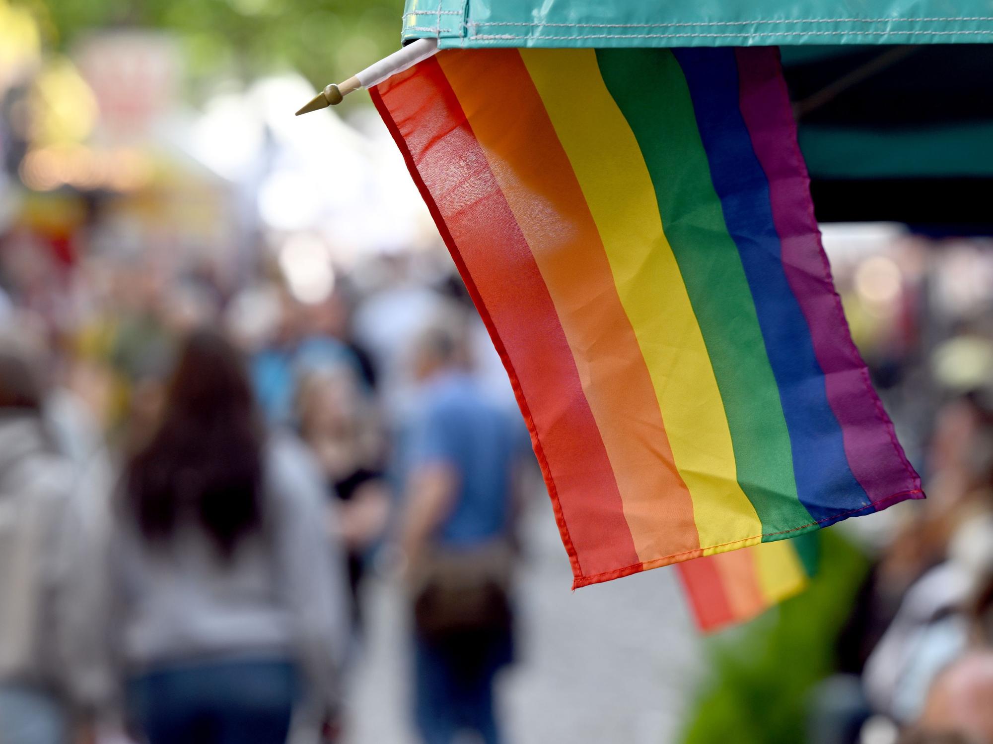 Regenbogenflaggen sind an einem Marktstand angebracht.