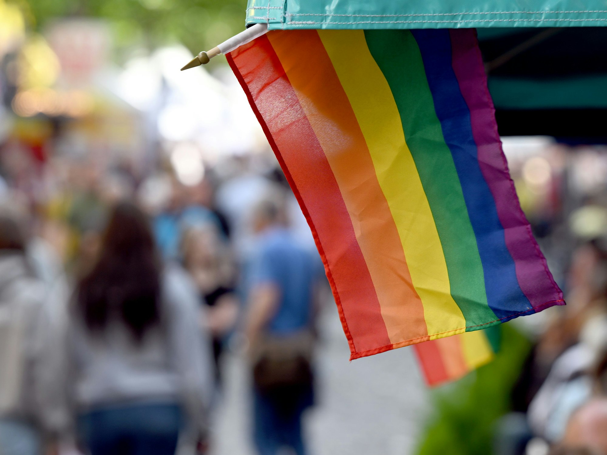 Regenbogenflaggen sind an einem Marktstand angebracht.