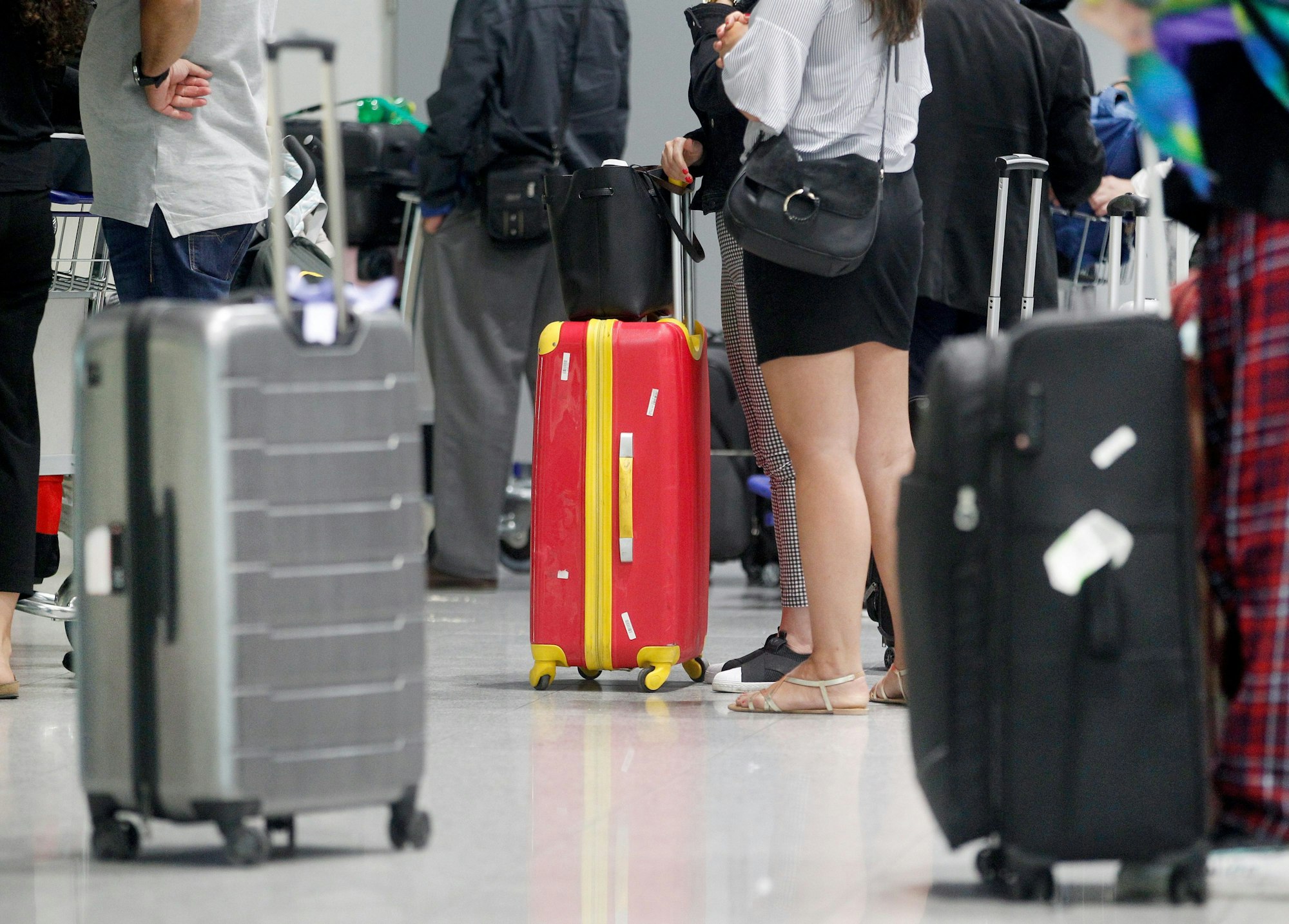 Fluggäste warten am Düsseldorfer Flughafen vor einem Check-In-Schalter auf ihre Abfertigung. Im Vergleich zu anderen Ländern zahlen deutsche Reisende rund 30 Prozent mehr für ihre Reisebuchungen. Symbolfoto vom 31. Mai 2022.