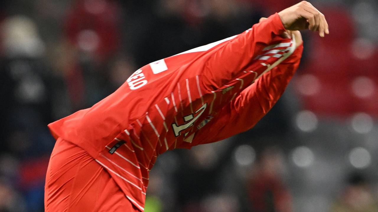 Joao Cancelo zieht sich das Trikot des FC Bayern über den Kopf.