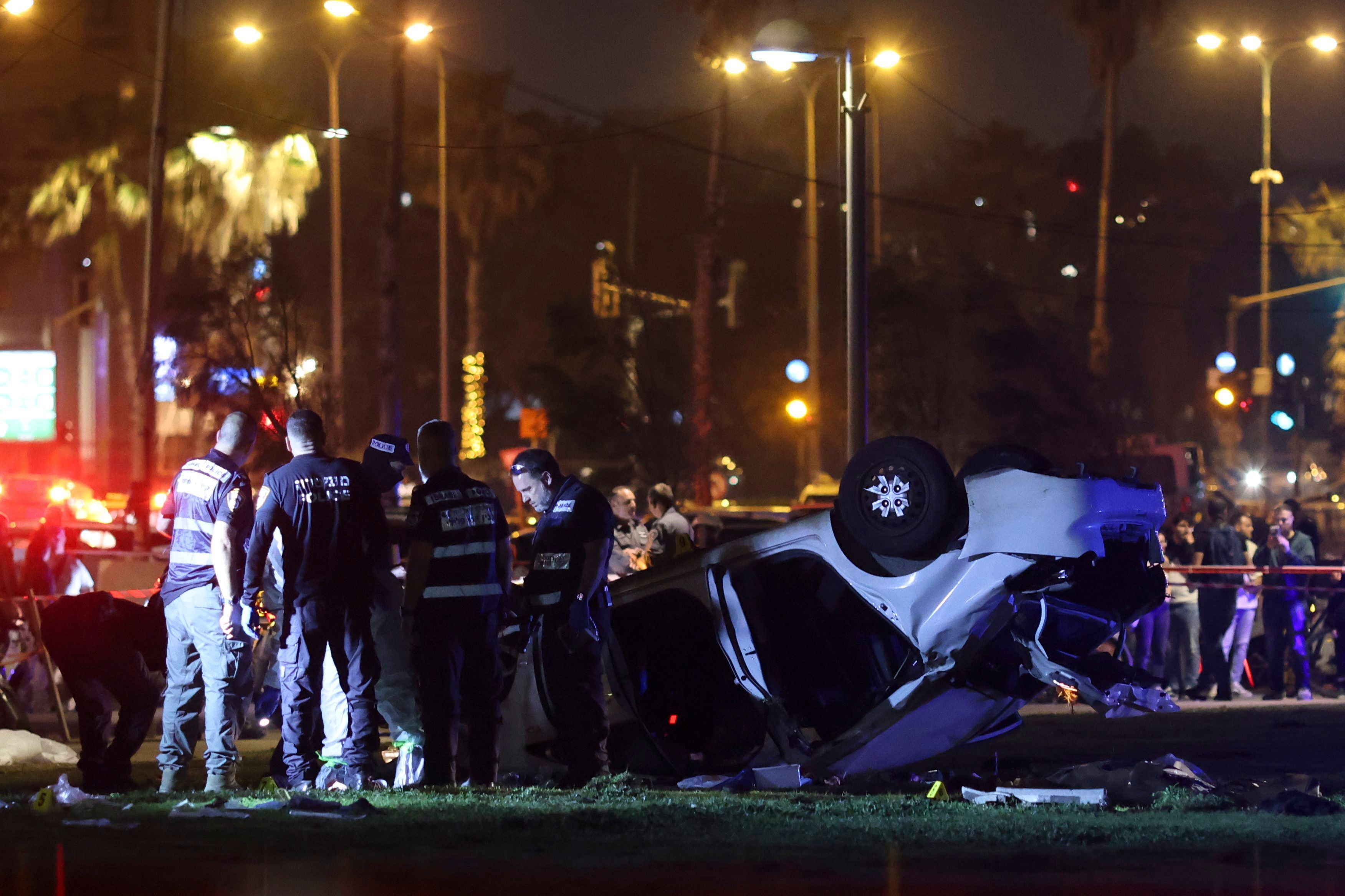Polizisten und Forensiker arbeiten neben einem Auto nach einem mutmaßlichen Anschlag in Tel Aviv.