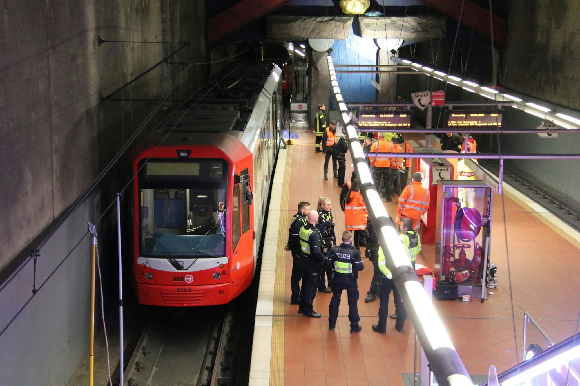 Polizei- und Rettungskräfte stehen an der KVB-Haltestelle, an der am Donnerstagabend (6. April 2023) ein Mann tödlich verunglückt ist.