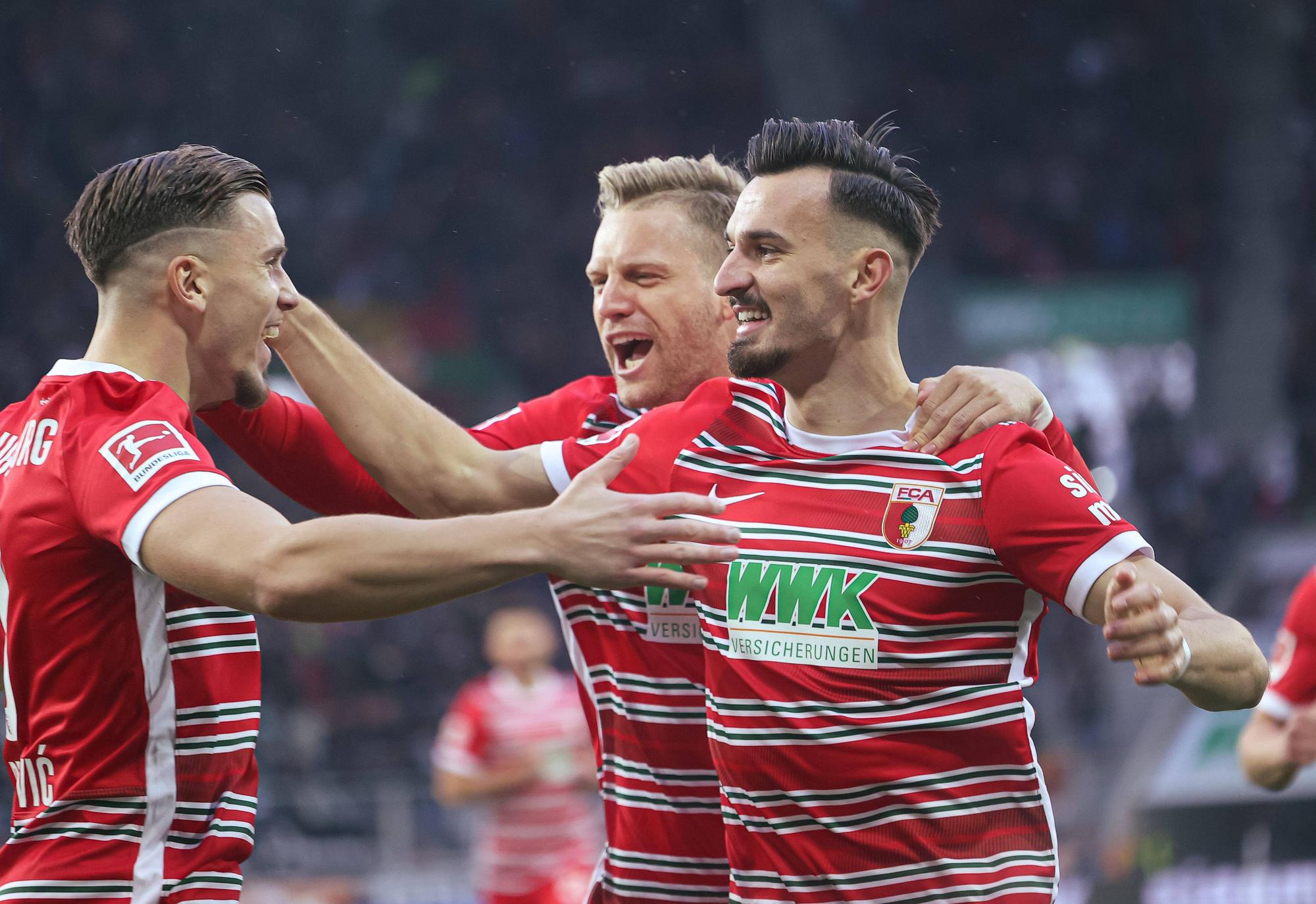 Augsburgs Mergim Berisha (r.), Arne Maier (Mitte) und Ermedin Demirovic jubeln gemeinsam.