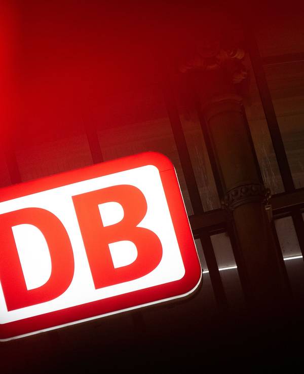 Das Logo der Deutschen Bahn leuchtet am Hauptbahnhof hinter einer Ampel in Frankfurt am Main, hier im Februar 2023.