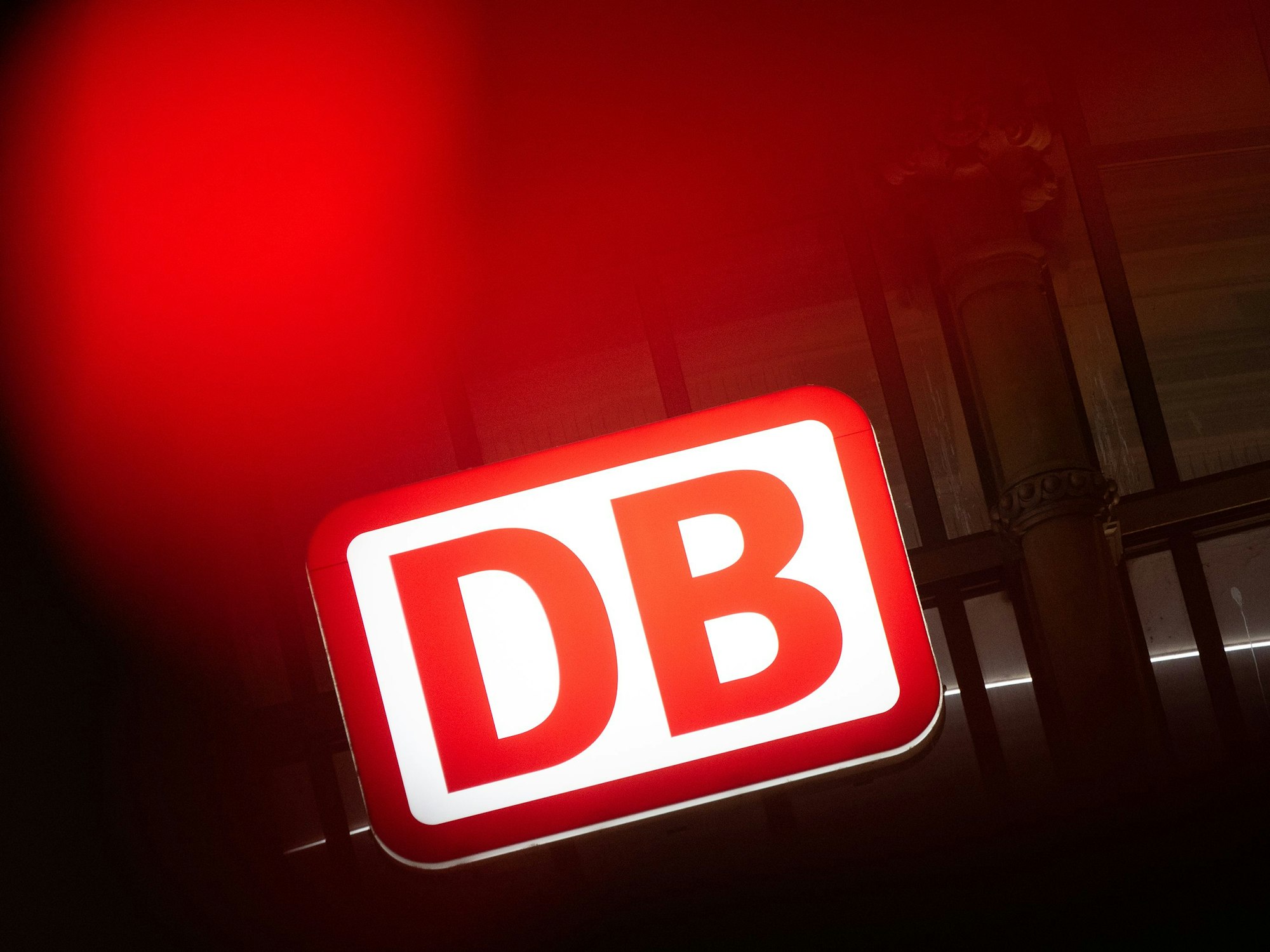 Das Logo der Deutschen Bahn leuchtet am Hauptbahnhof hinter einer Ampel in Frankfurt am Main, hier im Februar 2023.