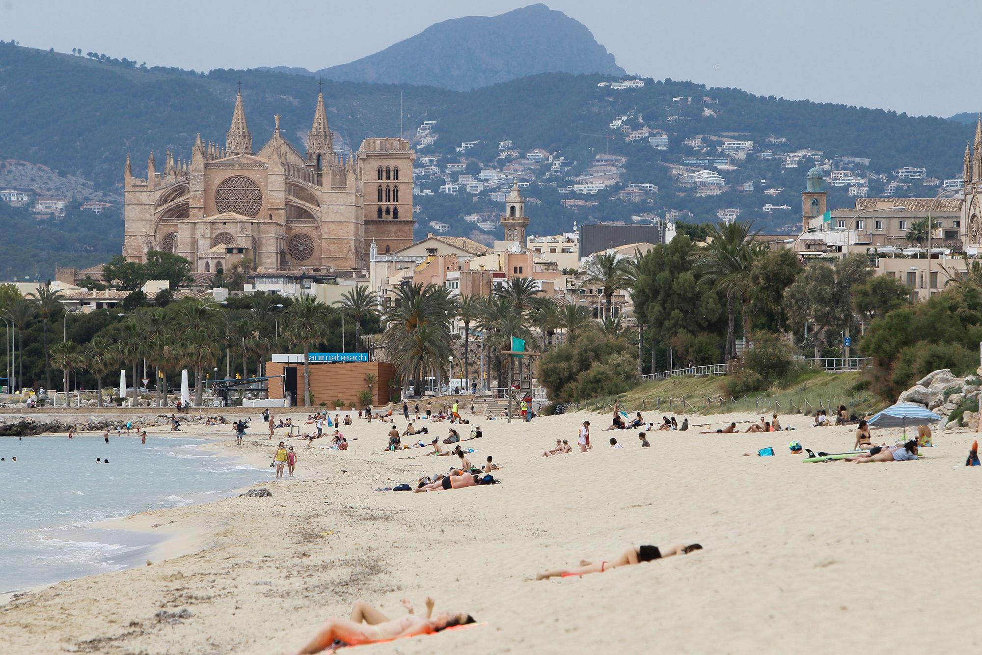 Badegäste liegen an einem Strand in Palma.