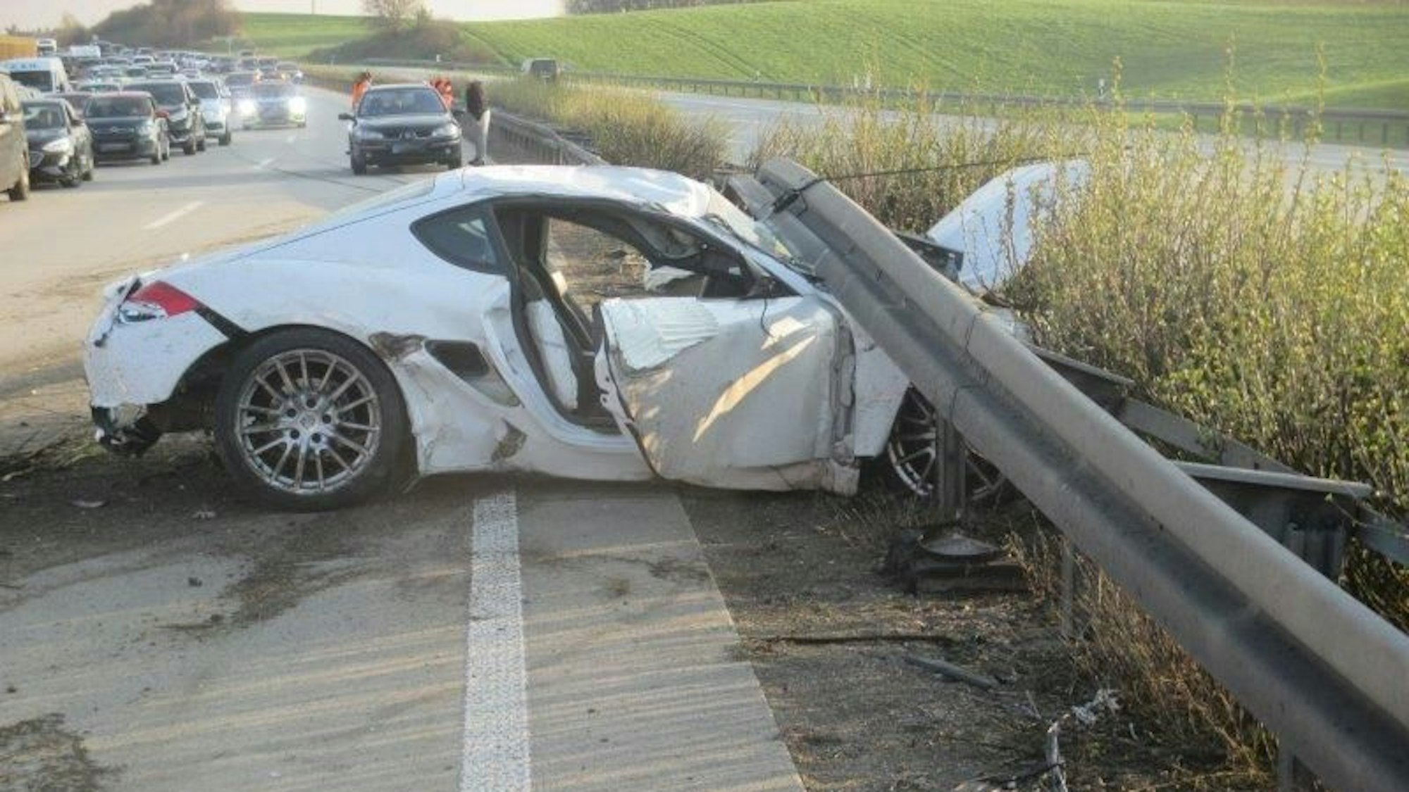 Ein Porsche klemmt nach einem Unfall auf der A9 bei Triptis (Thüringen) unter der Leitplanke.